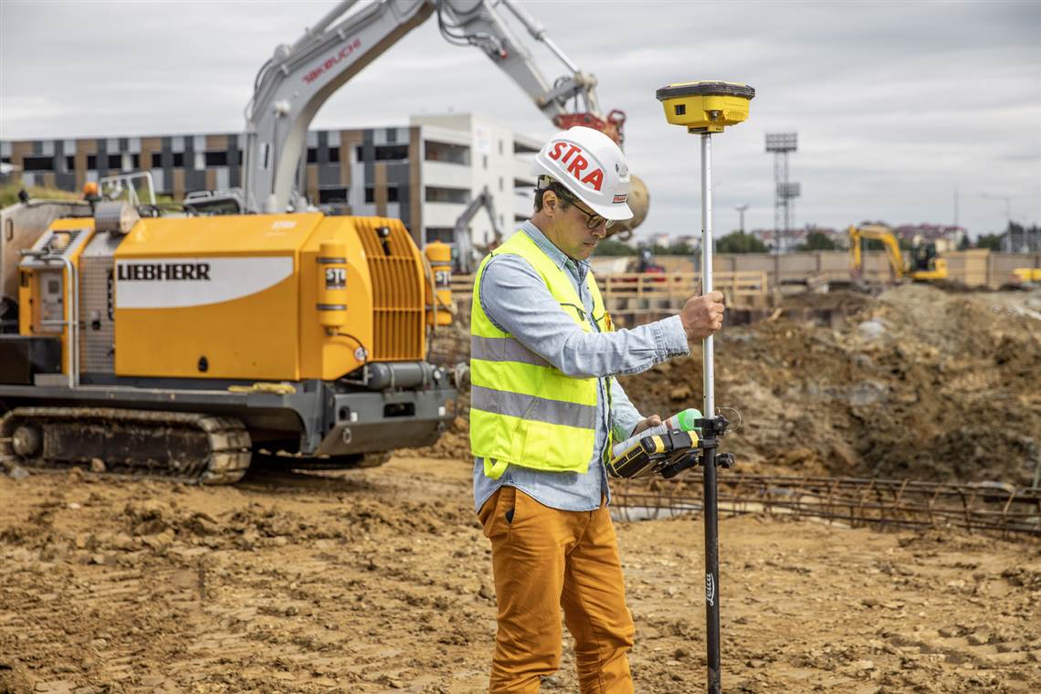 A ZÃ¼blin worker measures the jobsite to create a digital drilling map for the piles.